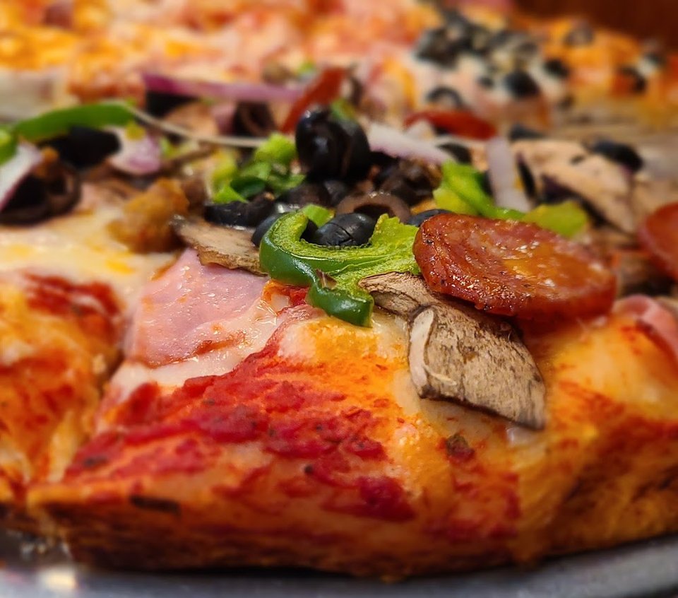 Printed menu with pizzas, sides, and drinks.